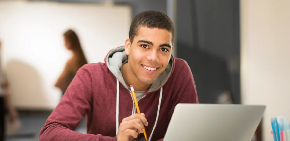 Student taking notes using his laptop